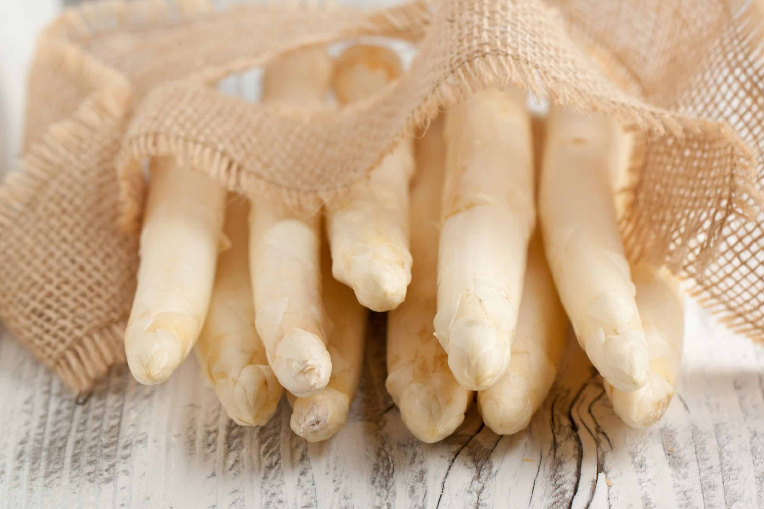 Bunch of fresh white asparagus on old wooden table